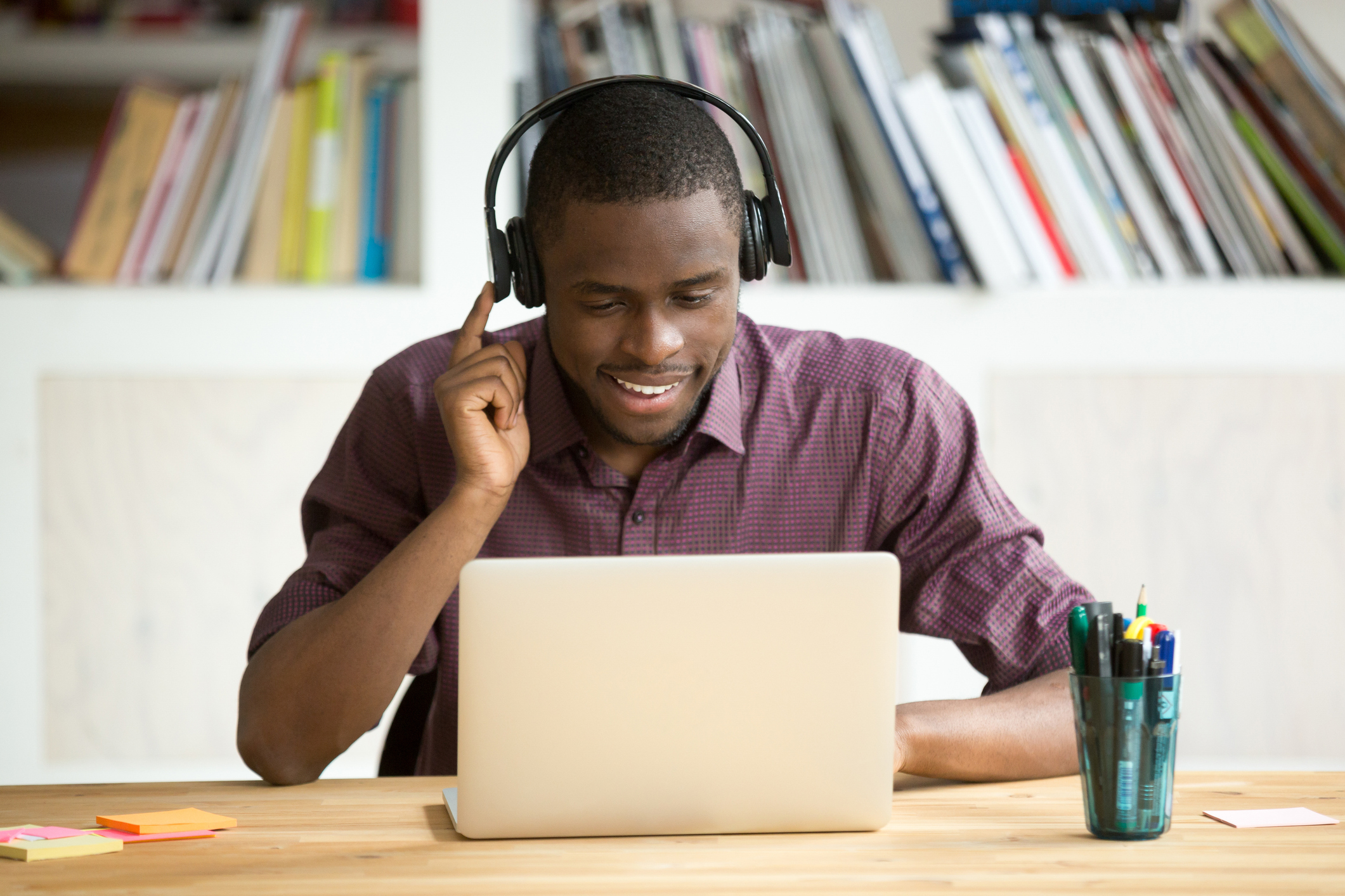 Man listening on headphones with a laptop