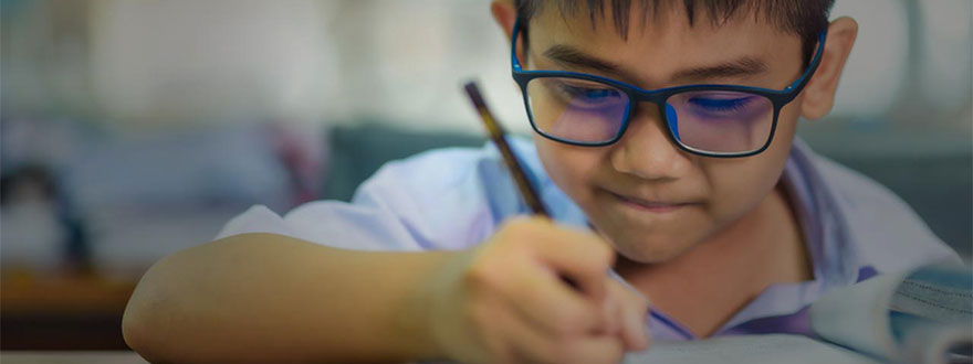 Boy with glasses writing